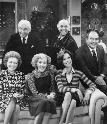 Ed Asner - Publicity photo of the cast of The Mary Tyler Moore Show in 1977. From left Standing: Ted Knight (Ted Baxter), Gavin MacLeod (Murray Slaughter), Ed Asner (Lou Grant). Seated: Betty White (